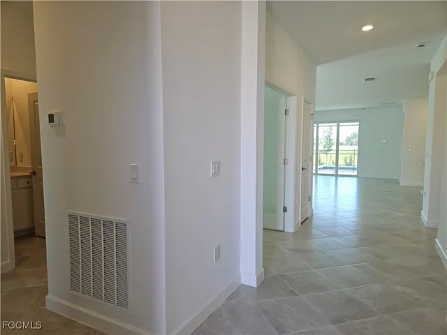 a view of a hallway with wooden floor and a bathroom