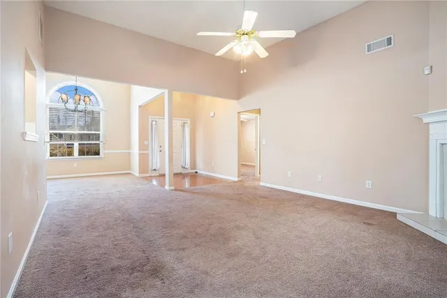 an empty room with windows and ceiling fan