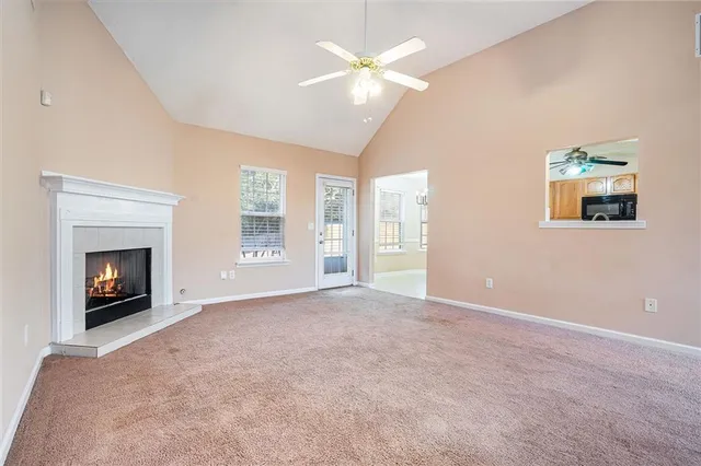 a view of an empty room with a fireplace and a window