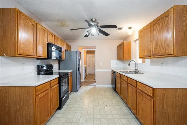 a kitchen with stainless steel appliances granite countertop wooden cabinets a sink and dishwasher