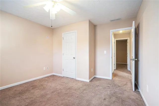 an empty room with chandelier fan