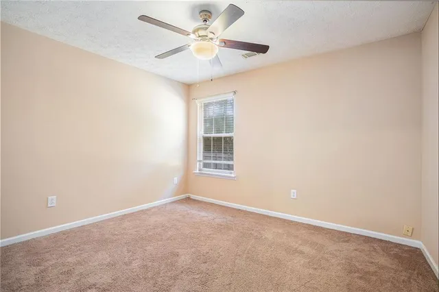an empty room and chandelier fan