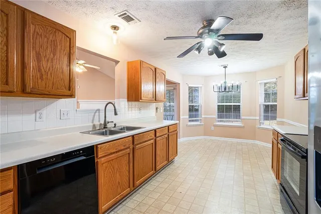 a large kitchen with stainless steel appliances granite countertop a sink and cabinets