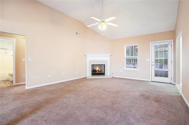 an empty room with windows and fireplace