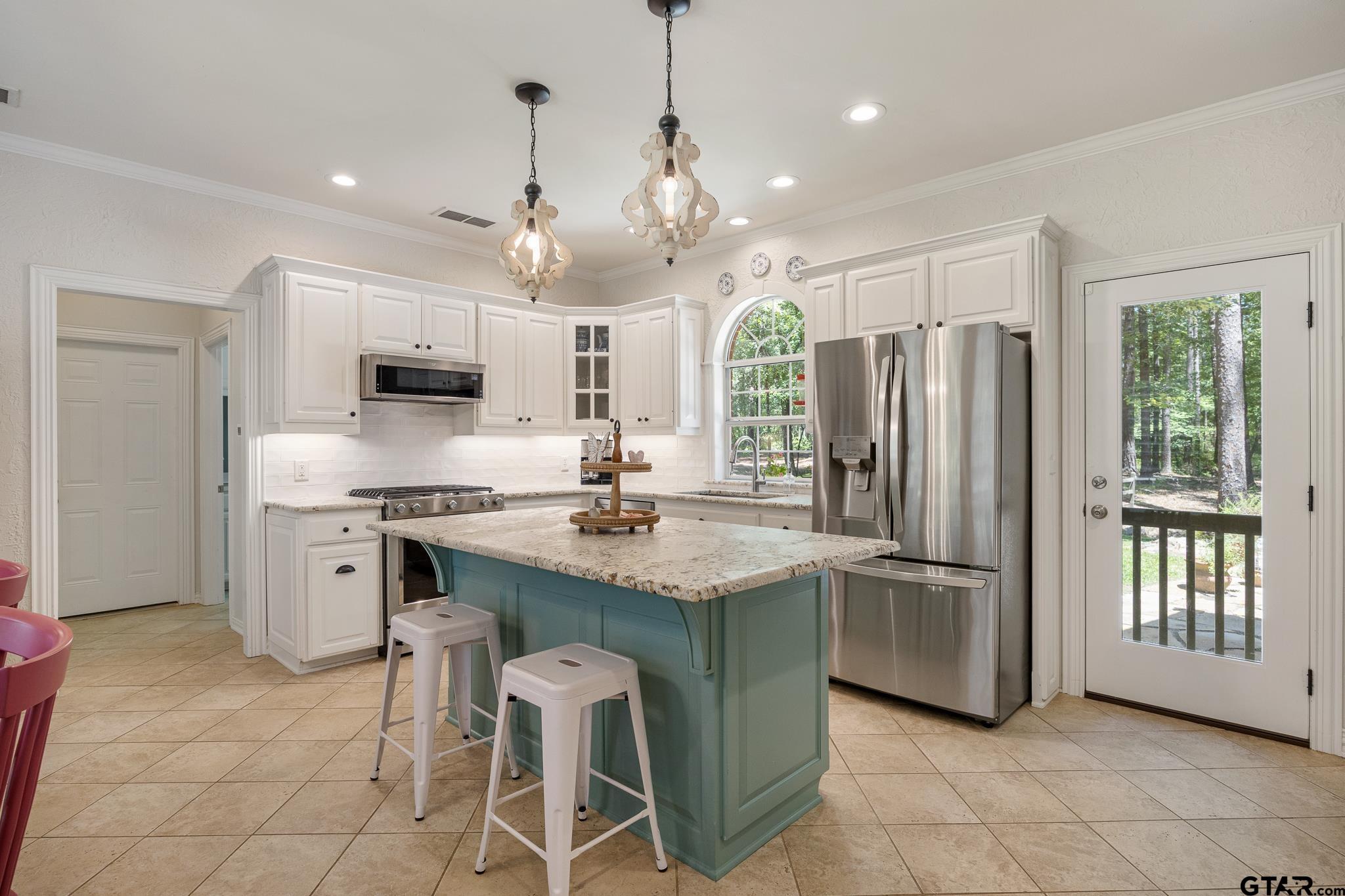 18076 Deer Trail Flint, TX 75762 - Photo 20 of 46 a kitchen with stainless steel appliances granite countertop a refrigerator a sink dishwasher a stove a dining table and chairs with wooden floor