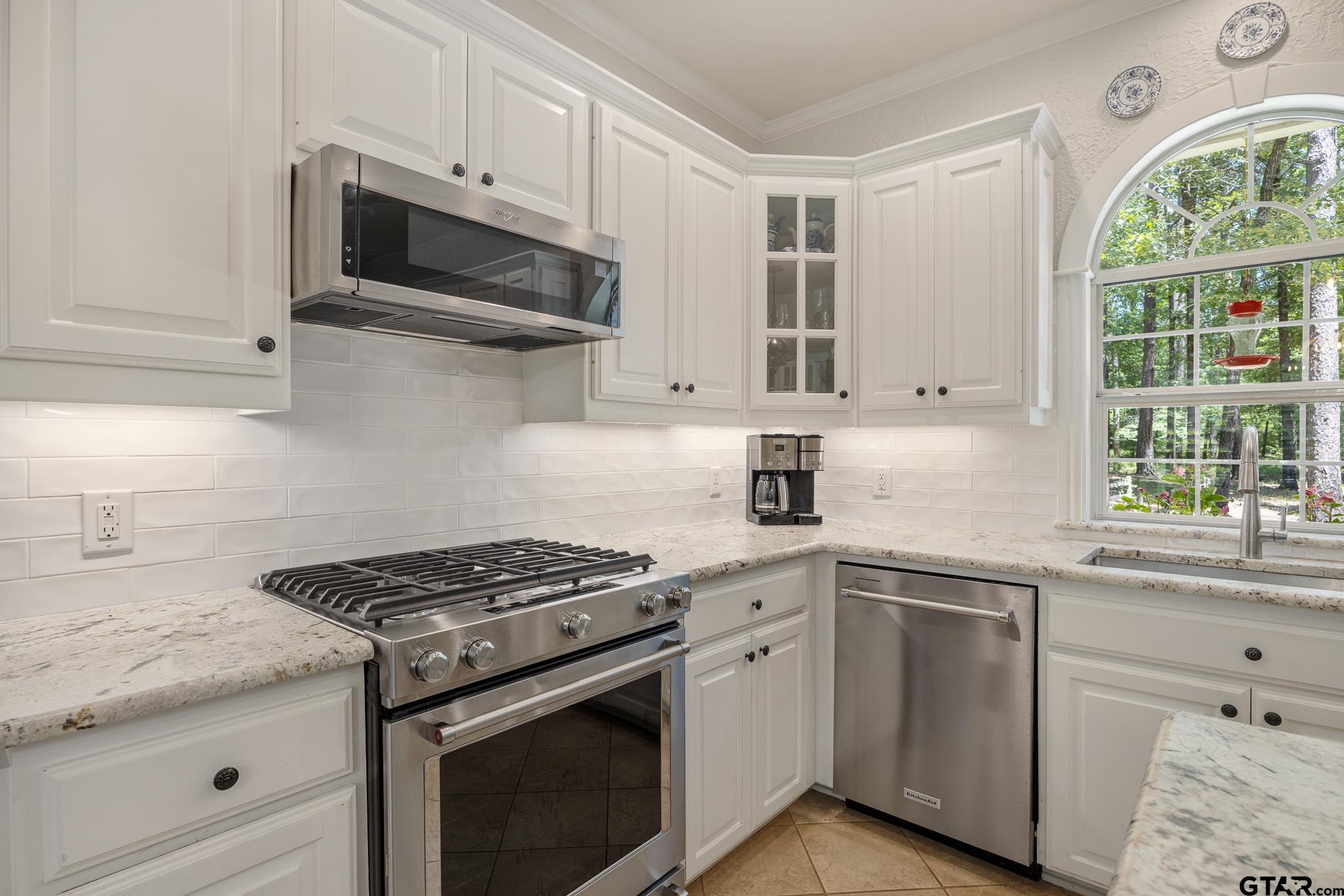 18076 Deer Trail Flint, TX 75762 - Photo 22 of 46 a kitchen with stainless steel appliances granite countertop white cabinets a window and a sink