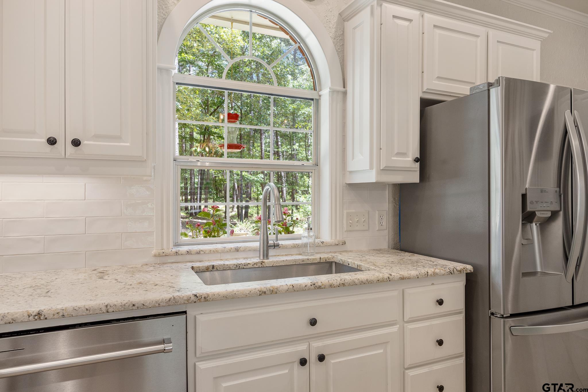 18076 Deer Trail Flint, TX 75762 - Photo 23 of 46 a kitchen with granite countertop a sink window and refrigerator