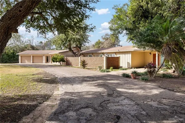 a view of a house with backyard and a tree