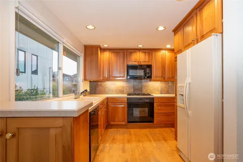a kitchen with stainless steel appliances granite countertop a sink a stove and a refrigerator