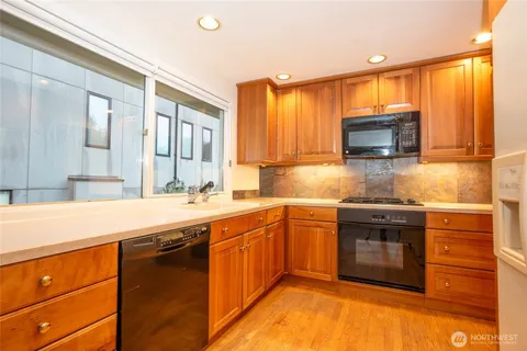 a kitchen with stainless steel appliances granite countertop a sink stove and microwave