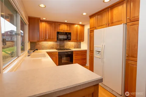 a kitchen with stainless steel appliances a refrigerator and a stove top oven