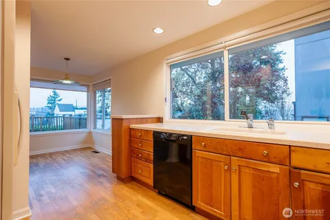 a view of open kitchen with a sink and wooden floor