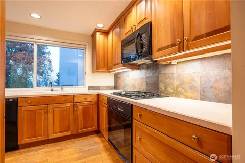 a kitchen with stainless steel appliances granite countertop a stove a sink and a microwave