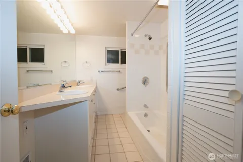 a bathroom with a granite countertop sink a mirror and a shower