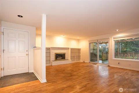 a view of a livingroom with wooden floor and a fireplace