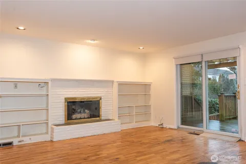 a view of an empty room with a fireplace and a window