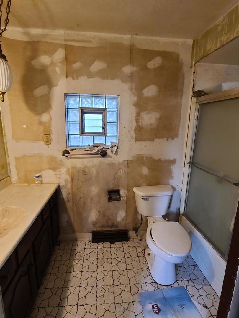 616 Ingraham Avenue Calumet City, IL 60409 - Photo 4 of 9 a bathroom with a granite countertop toilet a sink and a shower