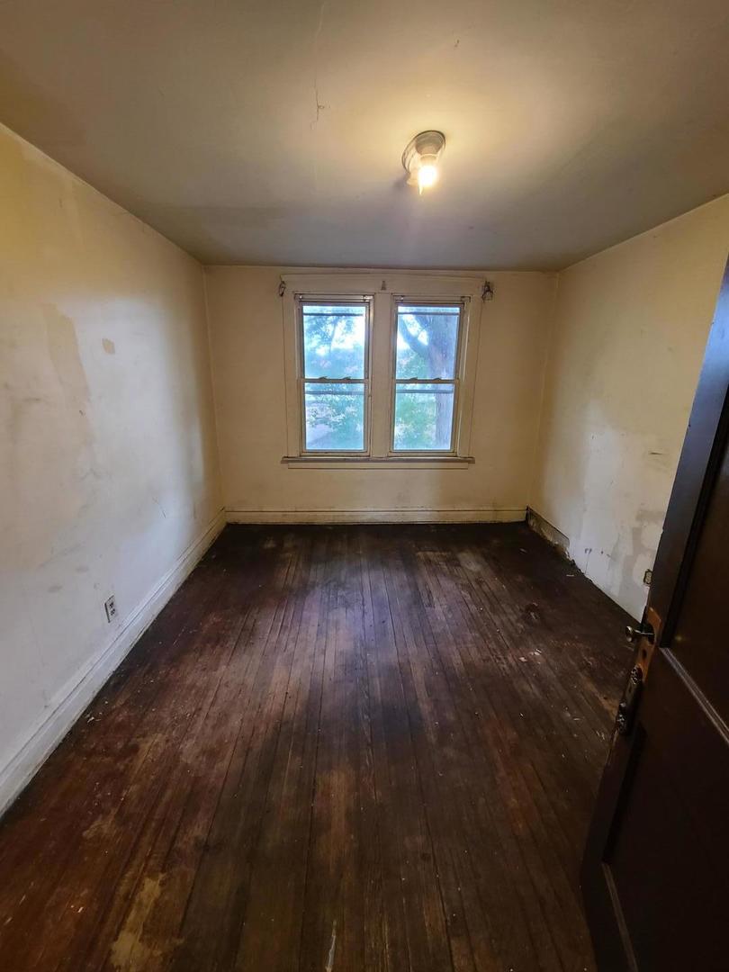 616 Ingraham Avenue Calumet City, IL 60409 - Photo 7 of 9 an empty room with wooden floor and windows