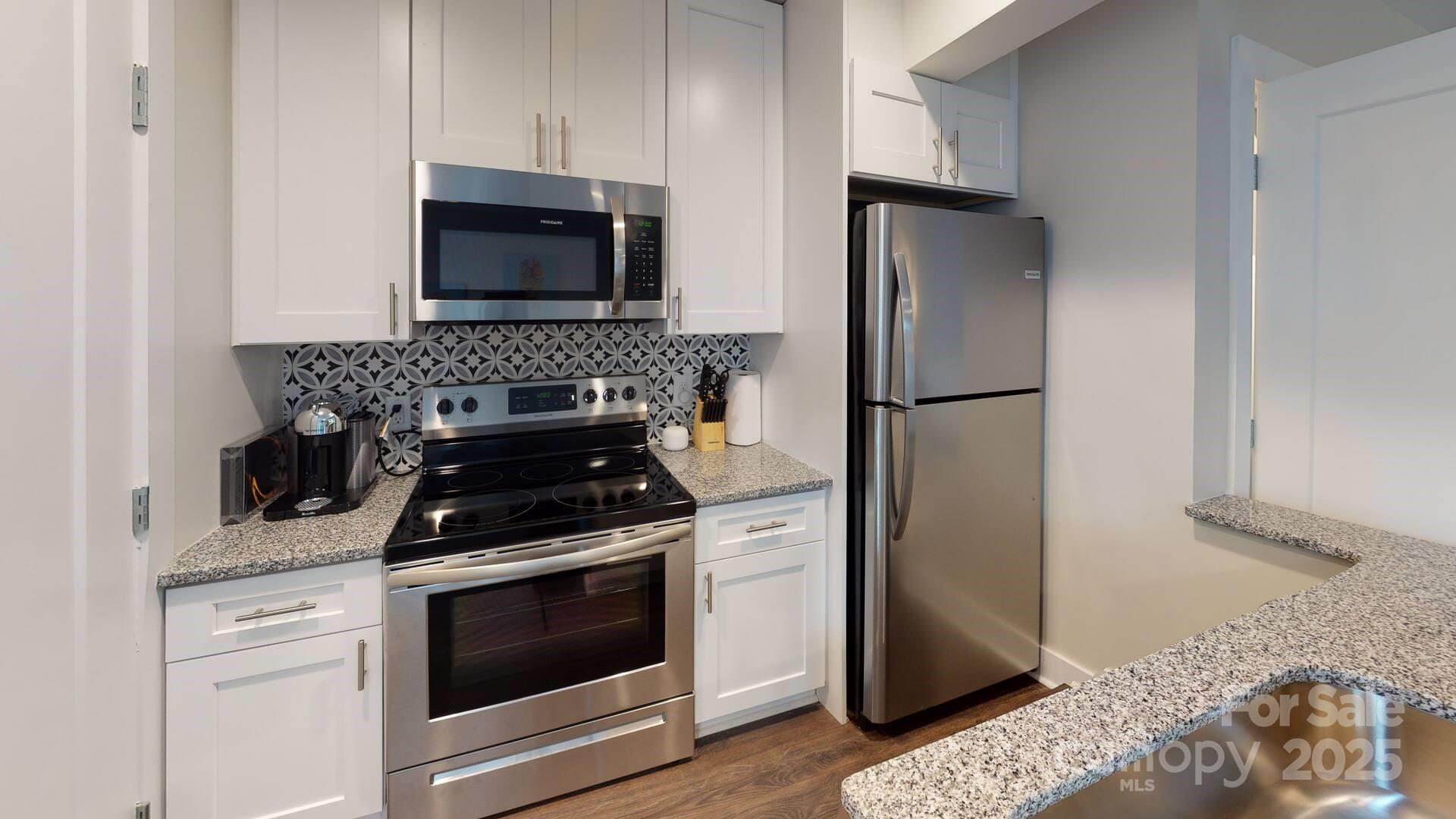 1909 Pegram Street Charlotte, NC 28205 - Photo 25 of 48 a kitchen with stainless steel appliances granite countertop a stove a refrigerator and a microwave