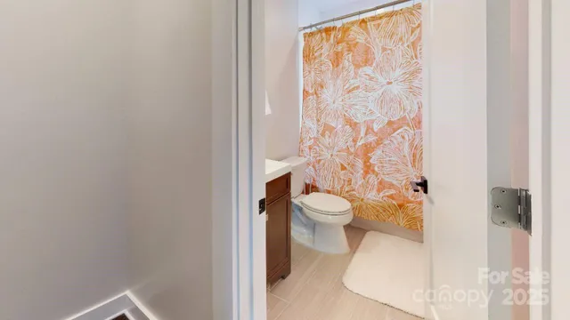 a white toilet sitting next to a shower curtain