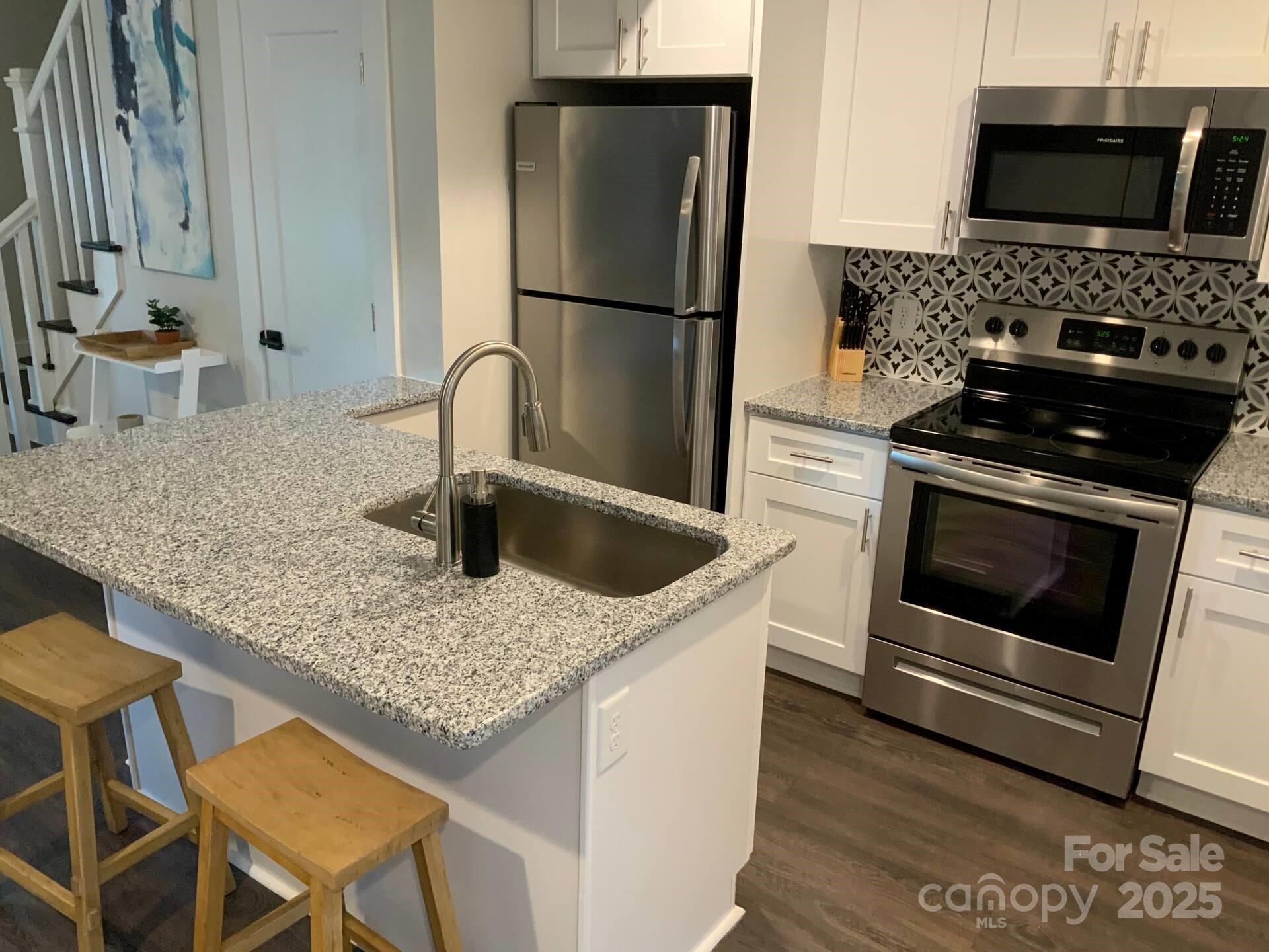 1909 Pegram Street Charlotte, NC 28205 - Photo 34 of 48 a kitchen with stainless steel appliances granite countertop a sink stove and refrigerator