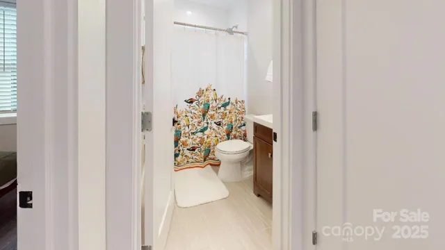 a bathroom with a toilet and a shower curtain