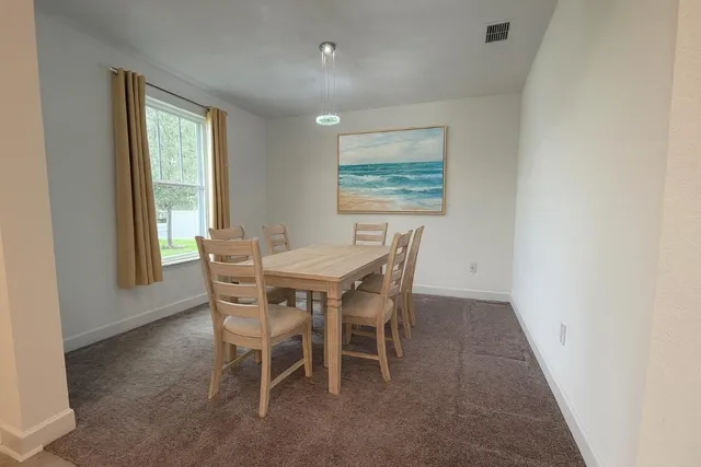 a dining room with furniture and window
