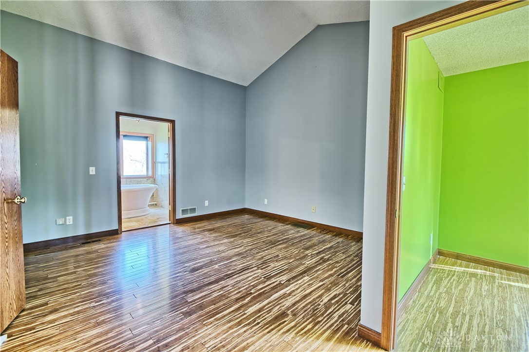 8711 Nicole Lane Springboro, OH 45066 - Photo 38 of 87 This primary bedroom showcases vaulted ceilings and wood flooring, with a connecting bath for added convenience.