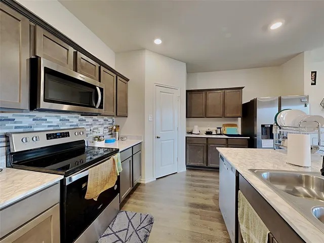 a kitchen with a sink stove and microwave