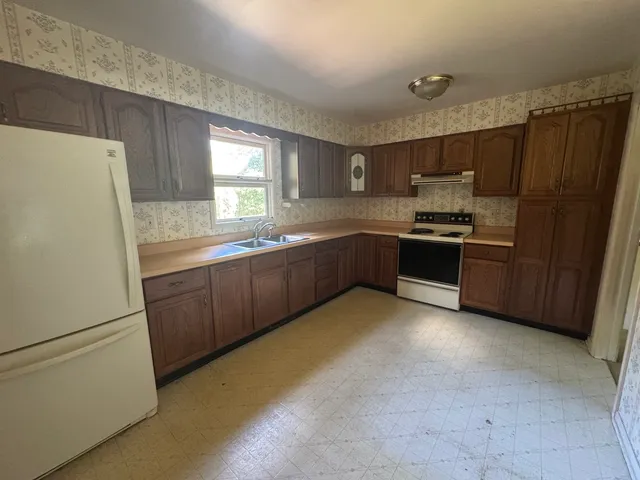 a kitchen with stainless steel appliances granite countertop a refrigerator a sink a stove a microwave and island