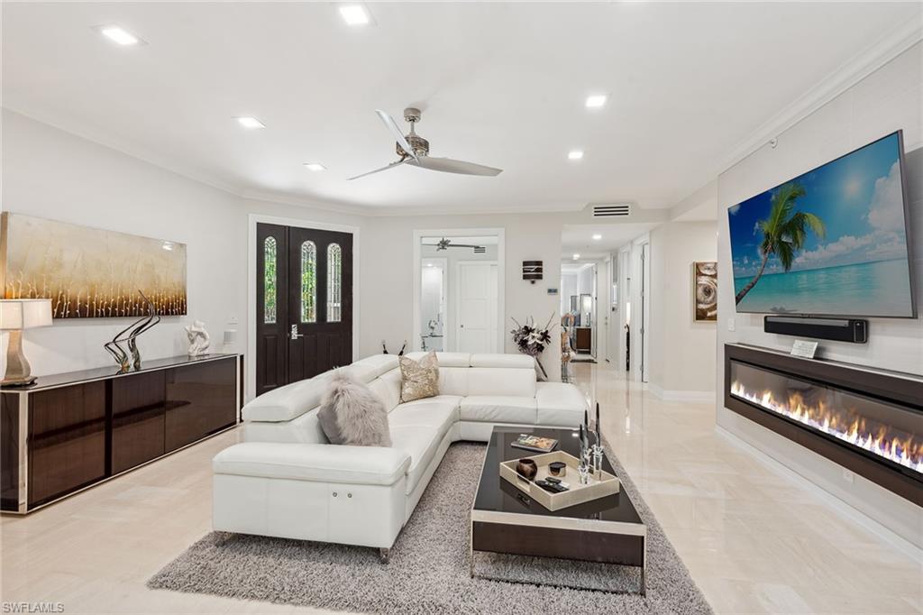 173 Colonade Circle, Unit 1401 Naples, FL 34103 - Photo 2 of 21 a living room with furniture a flat screen tv and kitchen view