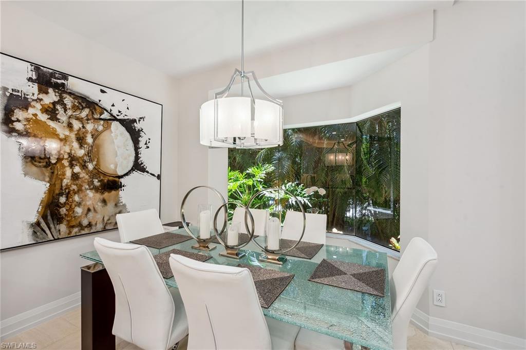 173 Colonade Circle, Unit 1401 Naples, FL 34103 - Photo 5 of 21 a view of a dining room with furniture and chandelier