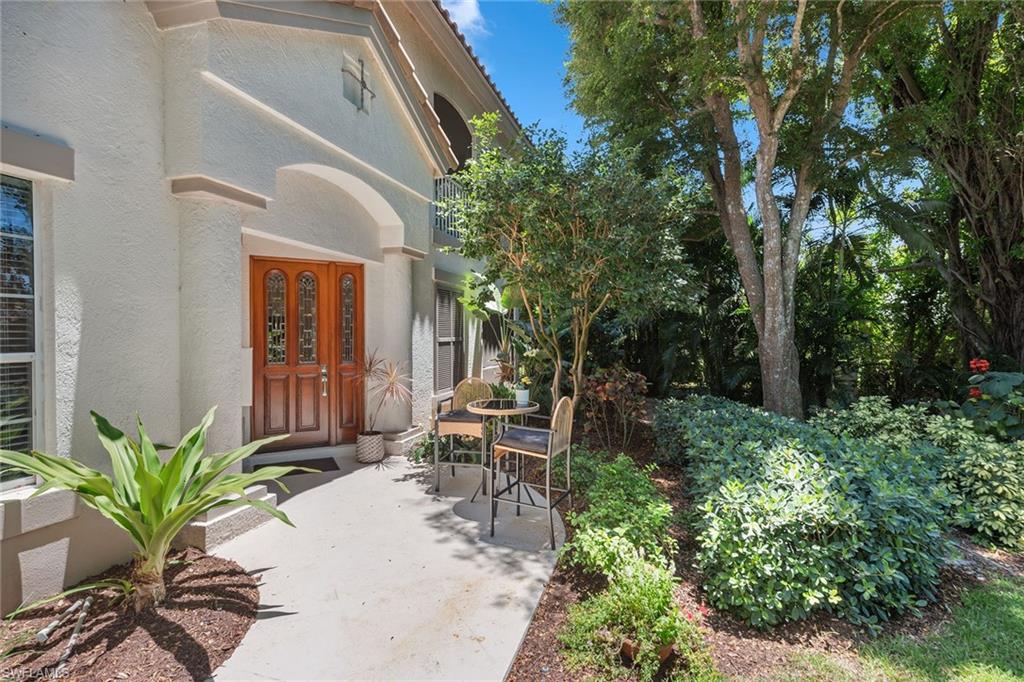 173 Colonade Circle, Unit 1401 Naples, FL 34103 - Photo 6 of 21 a view of a chair and tables in the backyard of a house