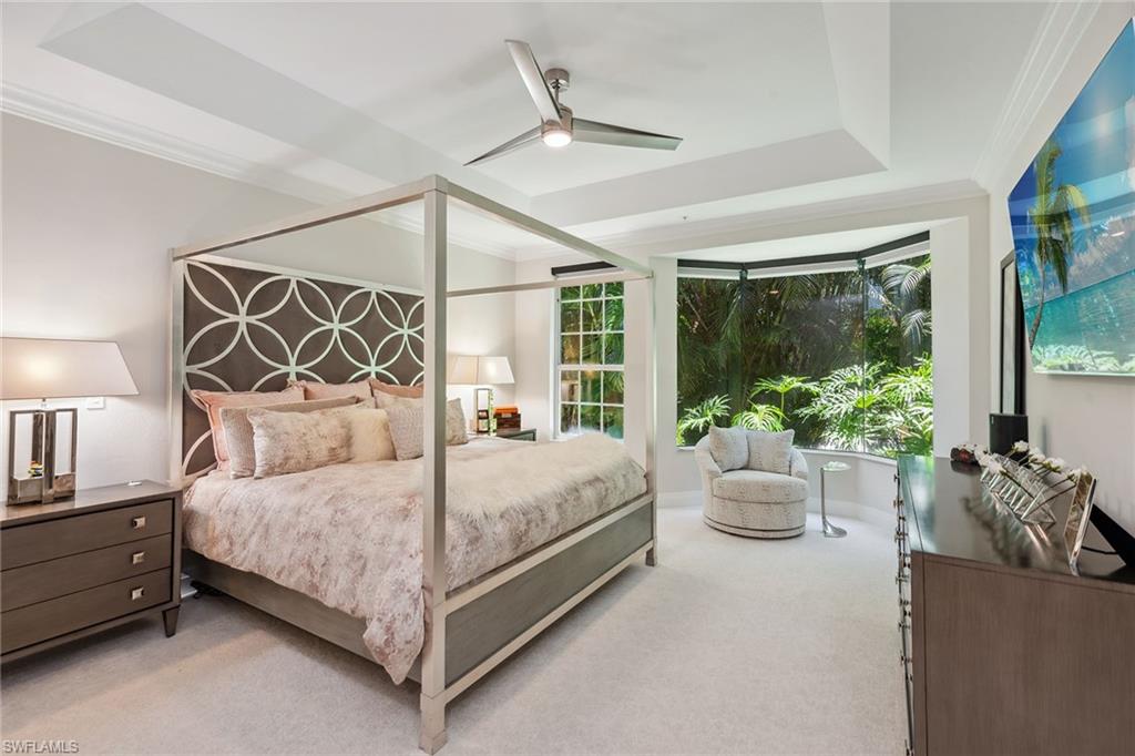 173 Colonade Circle, Unit 1401 Naples, FL 34103 - Photo 8 of 21 a bedroom with a bed a chandelier and a large window