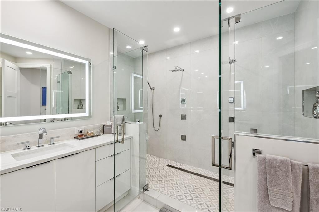 173 Colonade Circle, Unit 1401 Naples, FL 34103 - Photo 10 of 21 a bathroom with a shower sink double and mirror
