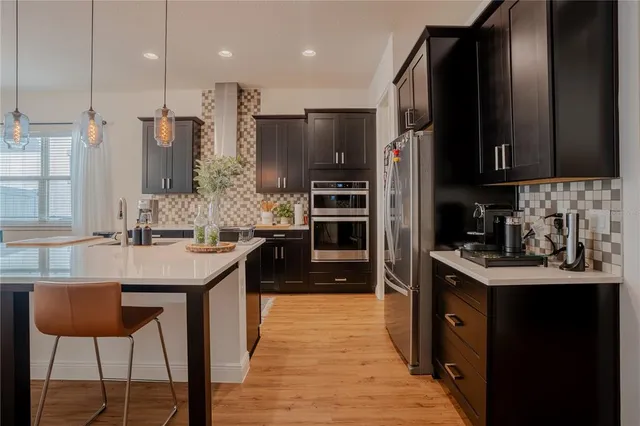 a kitchen with kitchen island a dining table and chairs