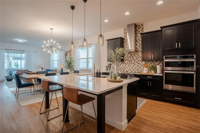 a open kitchen with stainless steel appliances granite countertop a sink a stove and a refrigerator