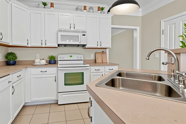 a kitchen with white cabinets and white appliances