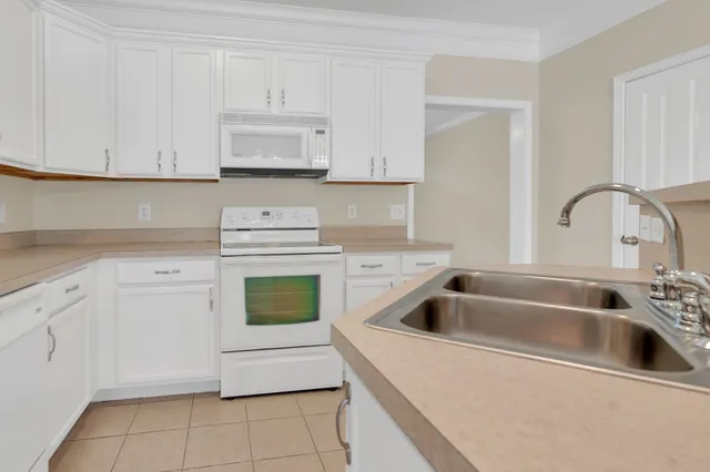 a kitchen with white cabinets stainless steel appliances and sink