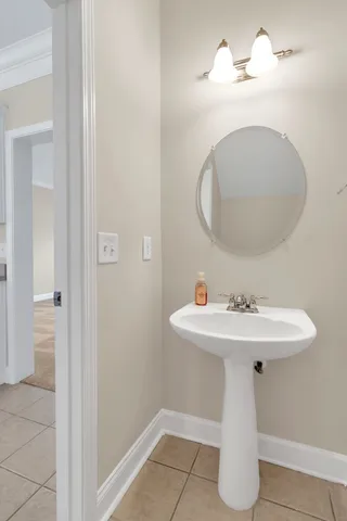 a white bath tub sitting next to a white toilet and wooden floor