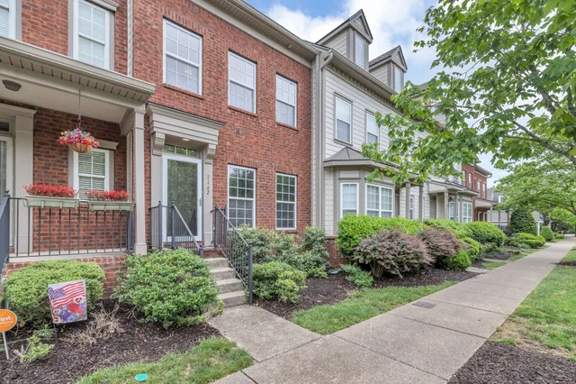 a front view of a house with yard and green space