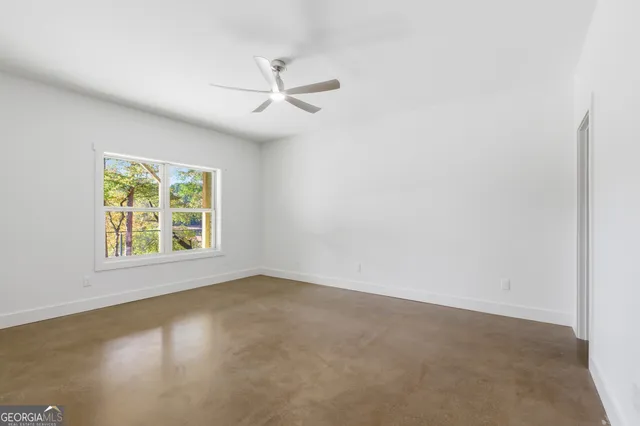 an empty room with a window and a ceiling fan