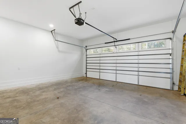 an aerial view of a residential houses with outdoor space and trees all around
