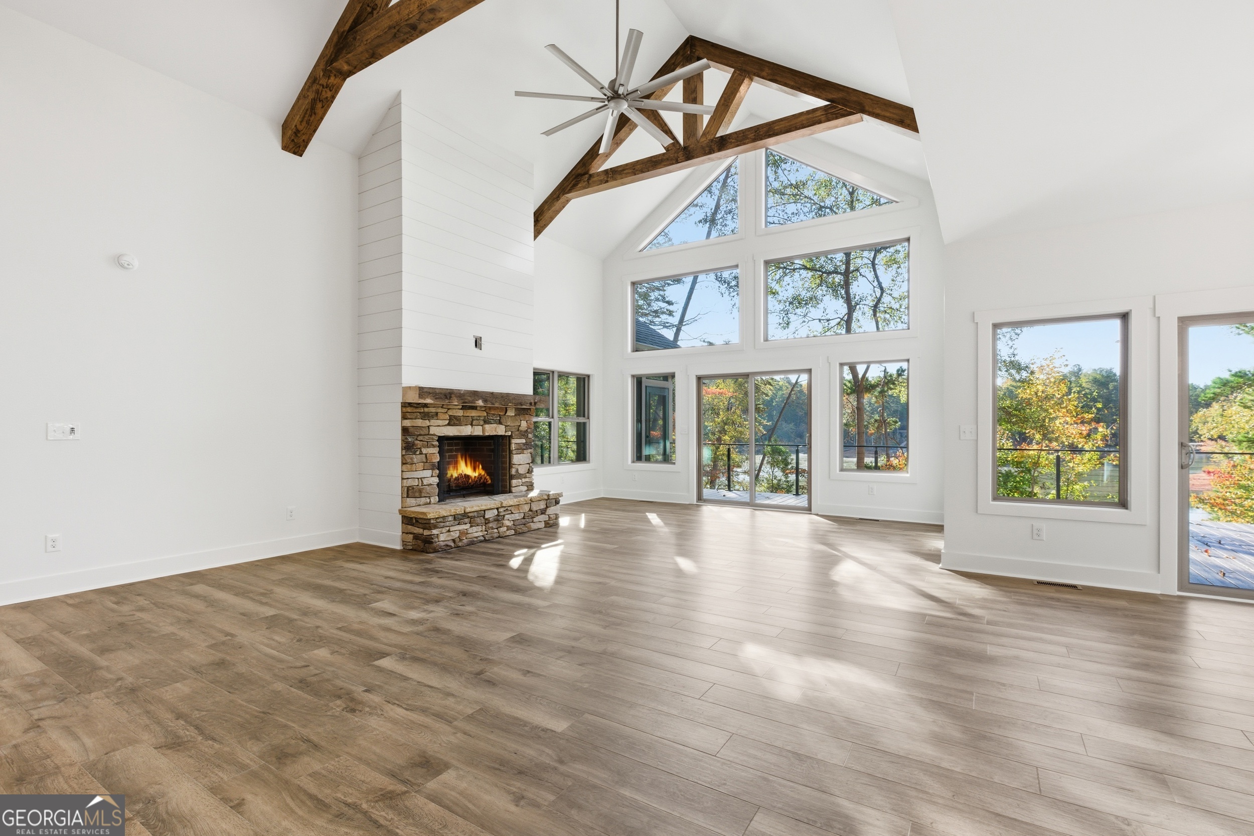 259 West Currahee Street Toccoa, GA 30577 - Photo 6 of 47 a view of an empty room with wooden floor fireplace and a window