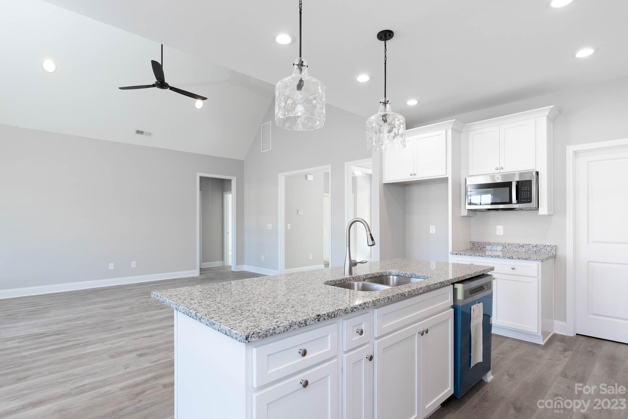 4639 Simpson Road Edgemoor, SC 29712 - Photo 13 of 30 a kitchen with kitchen island granite countertop a sink cabinets and wooden floor