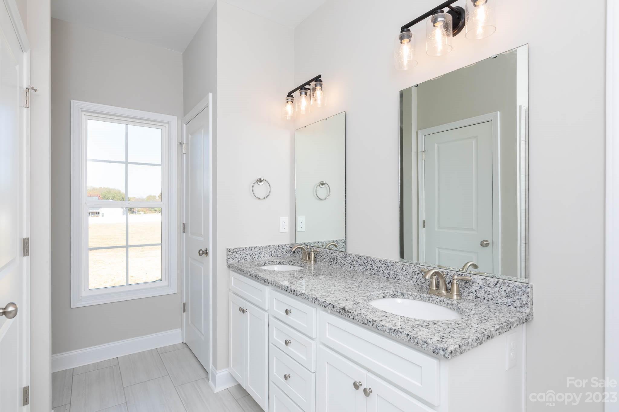 4639 Simpson Road Edgemoor, SC 29712 - Photo 9 of 30 a bathroom with a granite countertop sink and a mirror