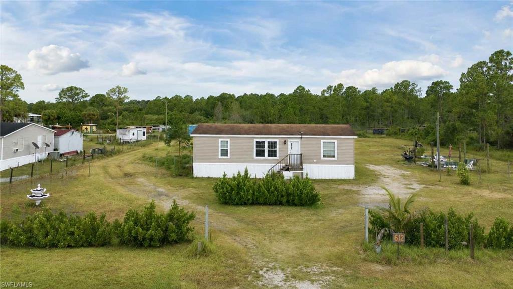 612 Hunting Clb Avenue Montura Ranches, FL 33440 - Photo 4 of 49 a view of a house with a yard