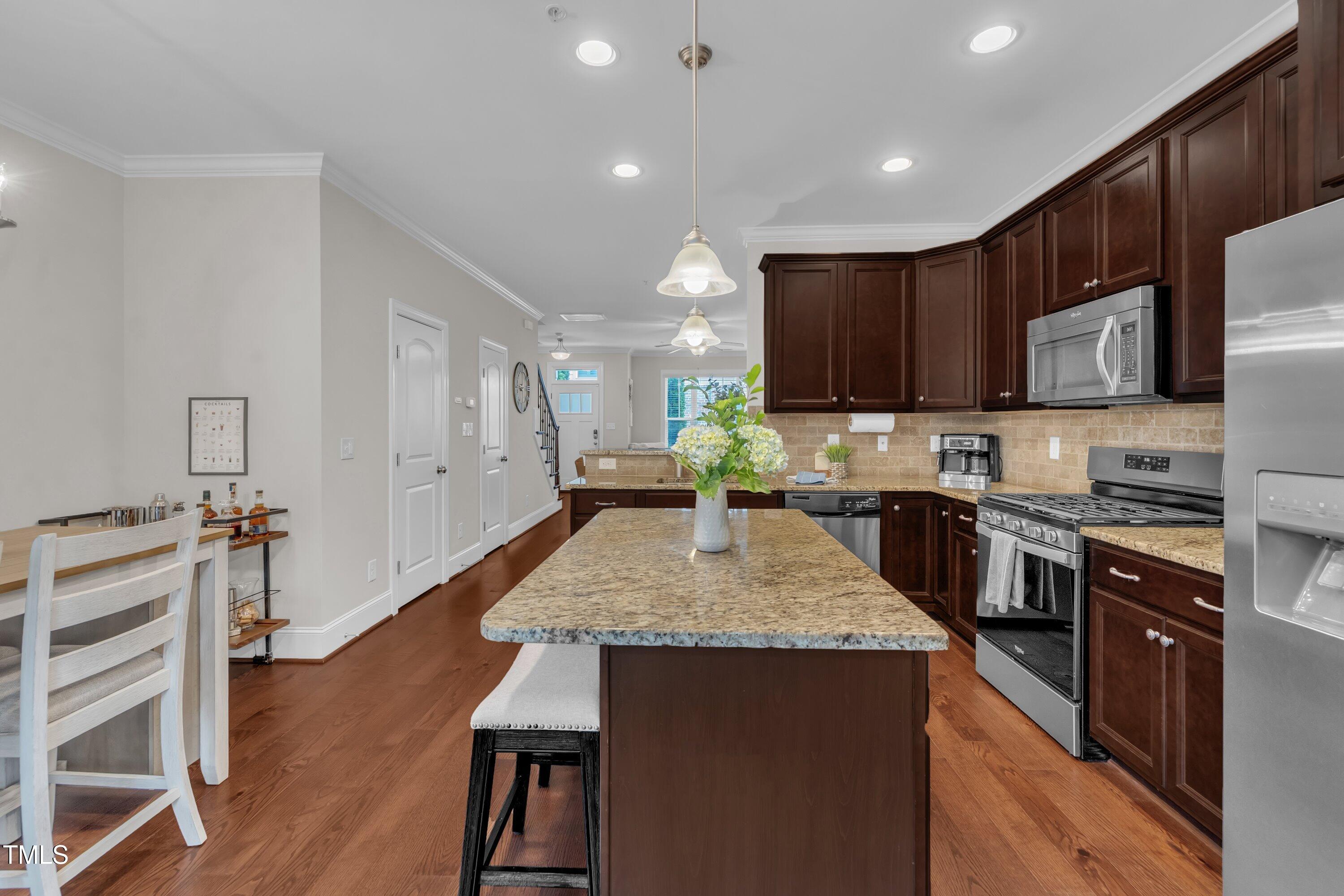 540 Ledbetter Court Raleigh, NC 27608 - Photo 15 of 40 a large kitchen with stainless steel appliances kitchen island granite countertop a stove a sink dishwasher and a microwave with wooden floor