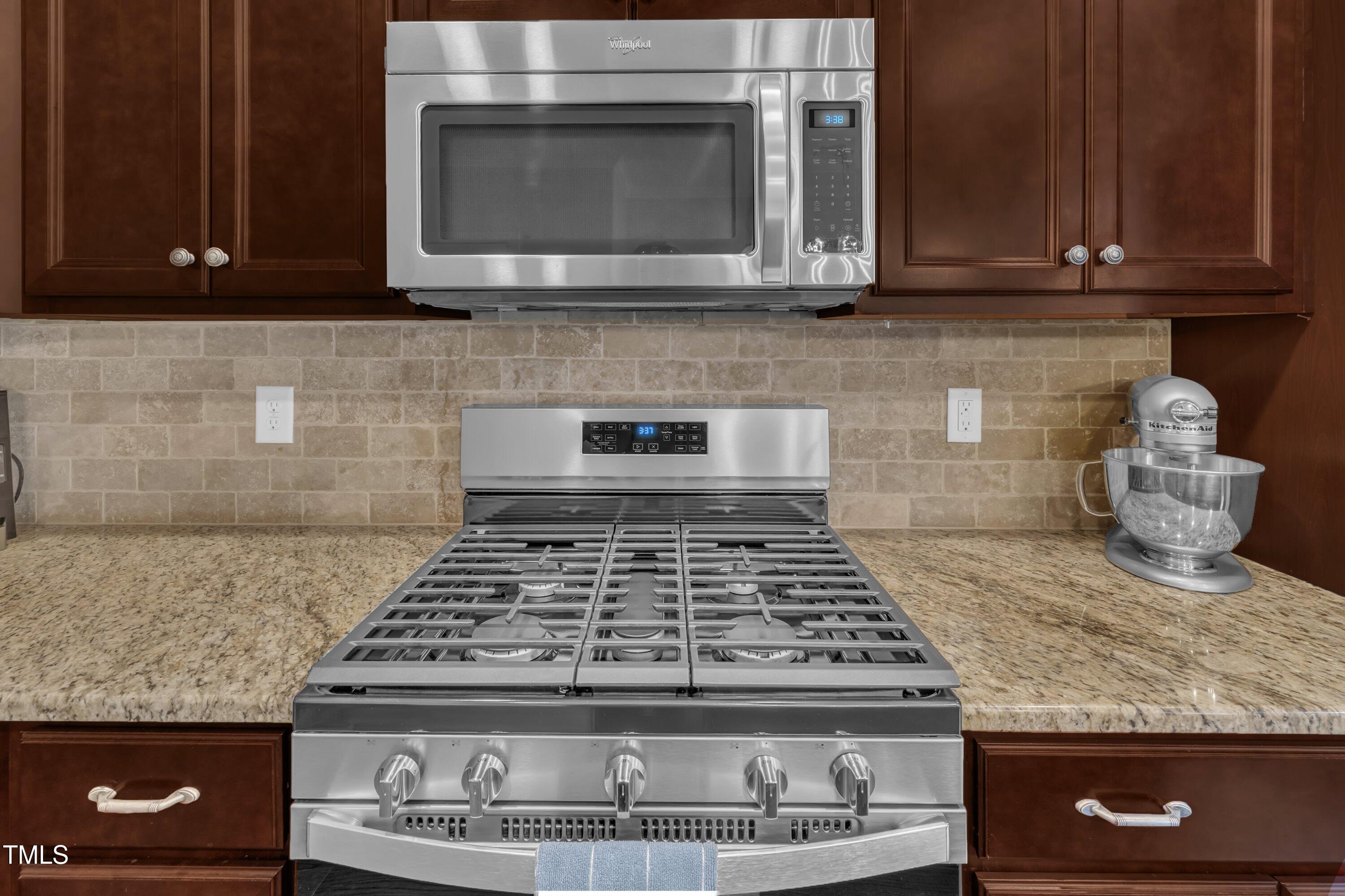 540 Ledbetter Court Raleigh, NC 27608 - Photo 16 of 40 a kitchen with granite countertop a stove top oven microwave and cabinets