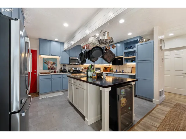 a kitchen with stainless steel appliances granite countertop a sink refrigerator and cabinets